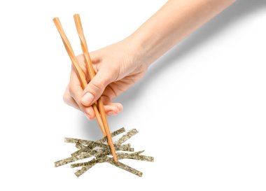 Çubuklu kadın eli ve beyaz arka planda Nori çarşafları.