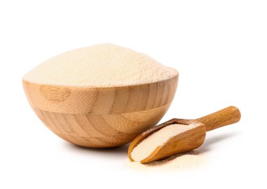 Beyaz arka planda çiğ irmik ile kase ve kepçe