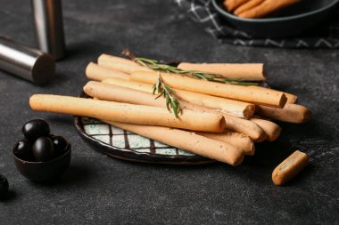 Koyu arkaplanda lezzetli İtalyan Grissini tabağı