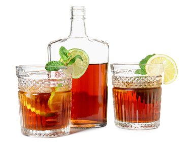 Beyaz arka planda limonlu soğuk rom şişesi ve bardakları