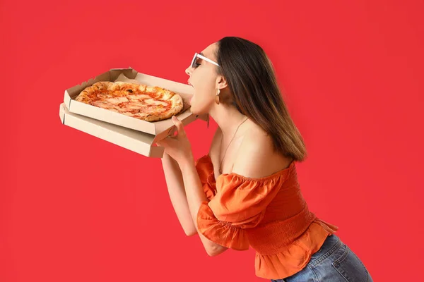 Güneş Gözlüklü Güzel Kadın Kırmızı Arka Planda Lezzetli Pizzalar Yiyor — Stok fotoğraf