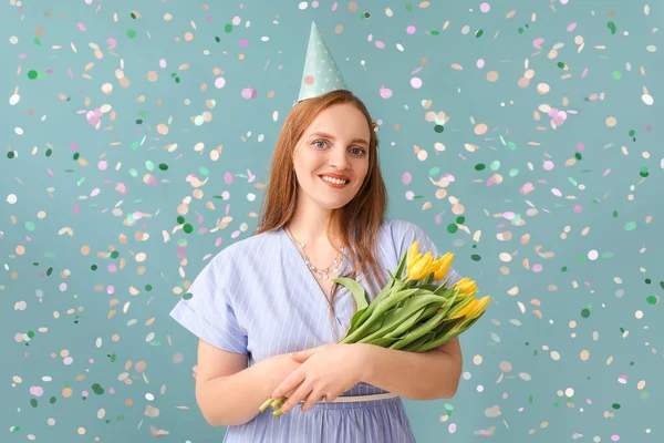 Beautiful woman with tulips celebrating Birthday on blue background