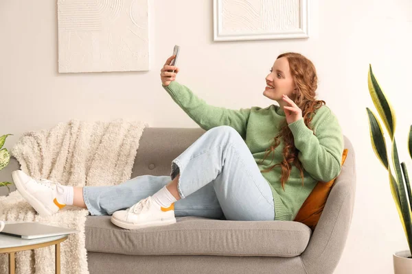 Όμορφη Κοκκινομάλλα Γυναίκα Κινητό Τηλέφωνο Λήψη Selfie Στον Καναπέ Στο — Φωτογραφία Αρχείου