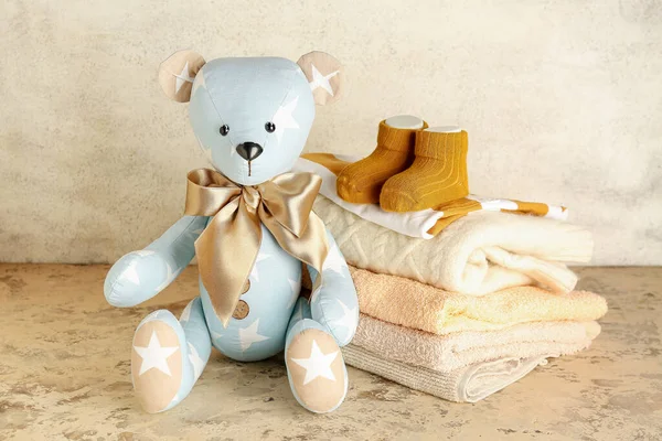 Urso Brinquedo Com Roupas Bebê Mesa Perto Parede Clara — Fotografia de Stock