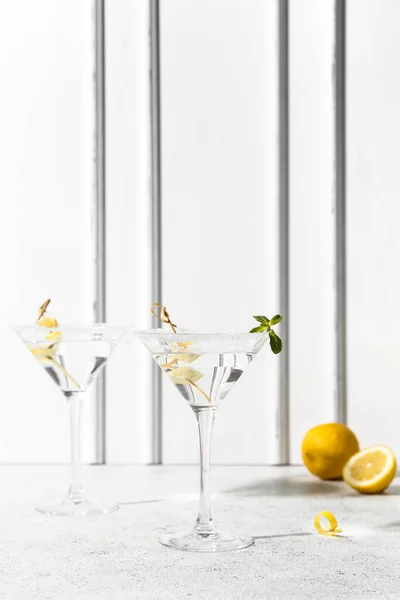 stock image Glasses of tasty martini and lemon on white table