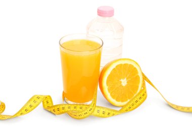 Bir bardak portakal suyu ve beyaz arka planda sarı mezura. Diyet kavramı
