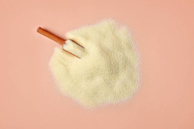 Pembe arka planda bir yığın çiğ irmik.