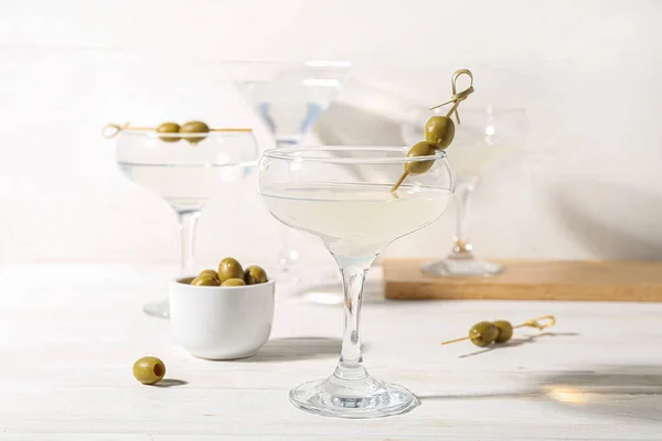 stock image Glasses of martini with olives on white wooden table