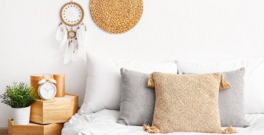 Beyaz duvarda şık bir düş kapanı asılı rahat bir yatak odası.