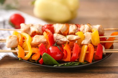 Tabakta lezzetli tavuk şişleri ve sebzeler var, yakın plan.