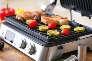 Lezzetli biftek ve sebzeli modern elektrikli ızgara.