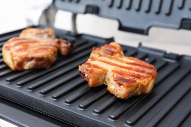 Modern elektrikli ızgarada leziz biftekler, yakın plan.