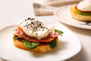 Benedict yumurtalı tabak beyaz masada, yakın plan.