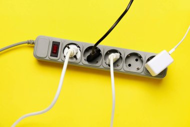 Sarı arka planda prizleri olan elektrik uzatma kablosu
