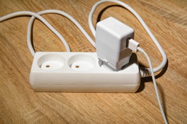 Tahta zemininde fişi olan elektrik uzatma kablosu.