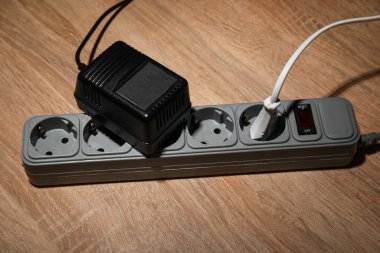 Tahta zemininde prizleri olan elektrik uzatma kablosu.