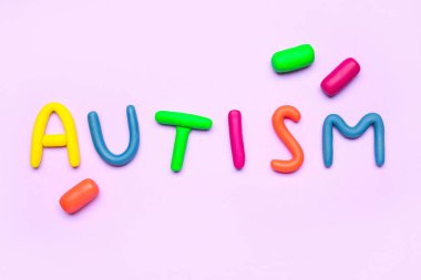 Leylak arkaplanındaki plastikten yapılmış kelime AUTISM