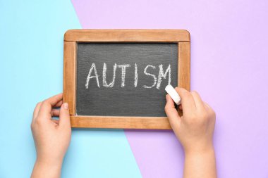 Renk arkaplanına AUTISM yazan çocuk