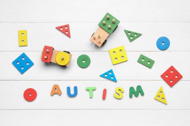 Kelime AUTISM beyaz ahşap arka planda bebek oyuncakları