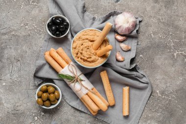 Humus, zeytin ve arkaplanda lezzetli İtalyan Grissini tabakları.