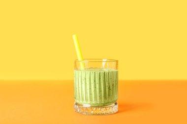 Renkli arkaplanda bir bardak yeşil smoothie