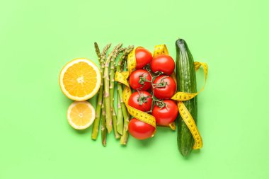 Sebzeler, yeşil arka planda limon ve sarı mezura. Diyet kavramı