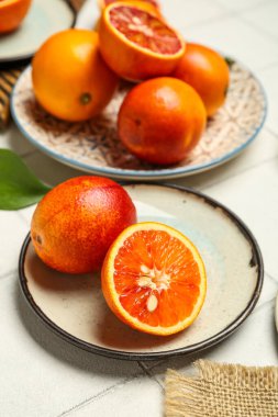 Arkaplanda lezzetli kan portakalları olan tabaklar.