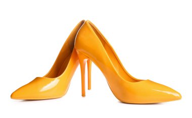 Beyaz arka planda sarı yüksek topuklu ayakkabılar.