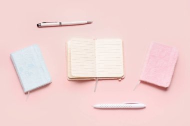 Renk arkaplanı üzerinde boş defter ve kırtasiye ile kompozisyon