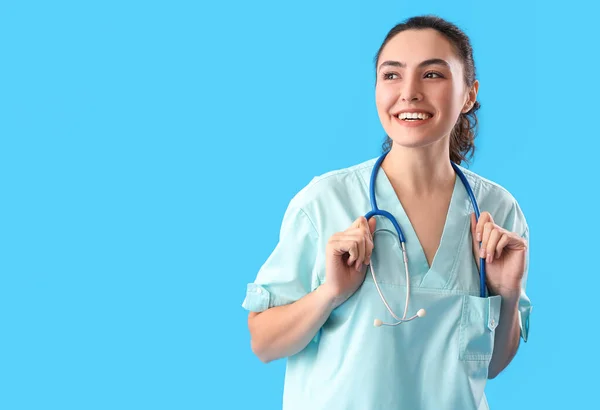 浅蓝色背景带听诊器的女医疗助理 — 图库照片