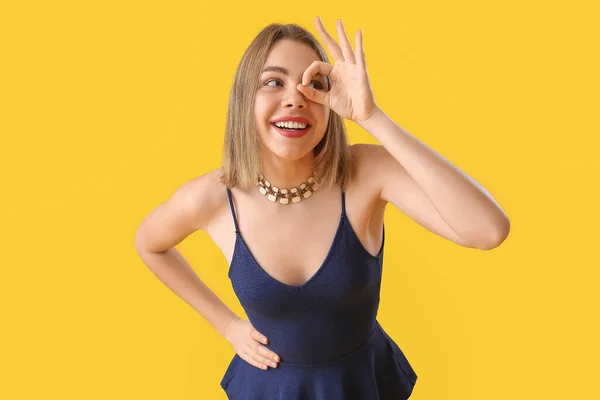 Junge Frau Mit Halskette Zeigt Auf Gelbem Hintergrund — Stockfoto