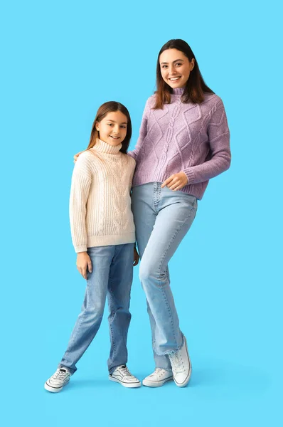 小女孩和她的母亲穿着蓝色背景的保暖毛衣 — 图库照片