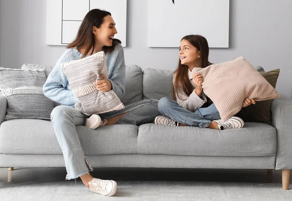 小さな女の子と彼女の母親で暖かいですセーター戦い枕で自宅 — ストック写真