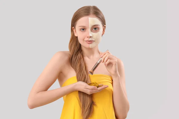 涂上姜黄面罩 刷子和灰底根的年轻妇女 — 图库照片