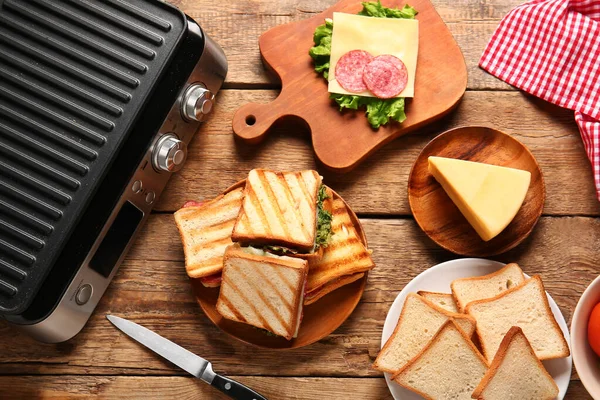 Composition Modern Electric Grill Delicious Sandwiches Wooden Table — Stock Photo, Image