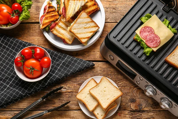 Composition Modern Electric Grill Delicious Sandwiches Wooden Table — Stock Photo, Image
