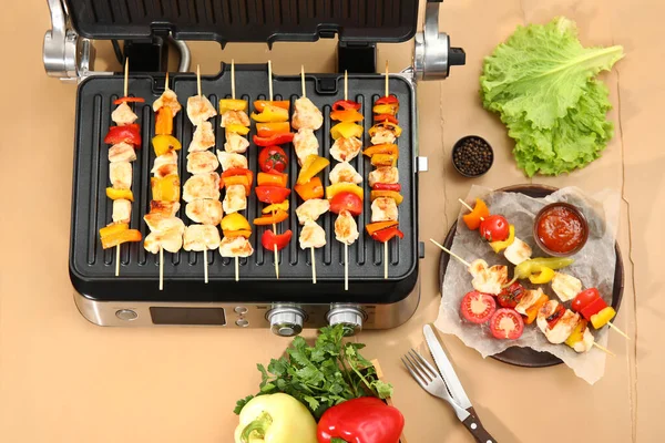 现代电烤炉 配上美味的鸡排和米色木制背景蔬菜 — 图库照片