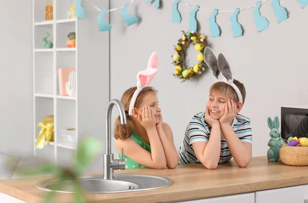 イースターの日に台所でウサギの耳を持つ小さな子供たち — ストック写真