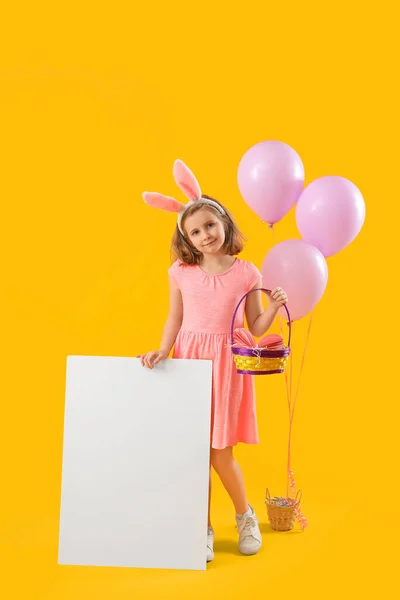 イースターの卵を持つ女の子 黄色の背景に空白のポスターと風船 — ストック写真