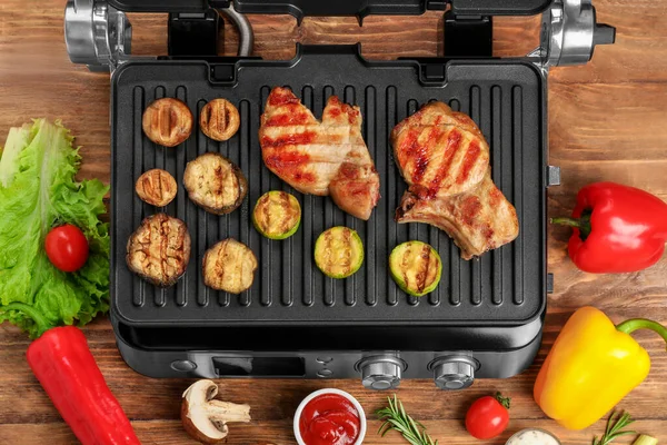 Modern Electric Grill Tasty Steaks Vegetables Wooden Background — Stock Photo, Image