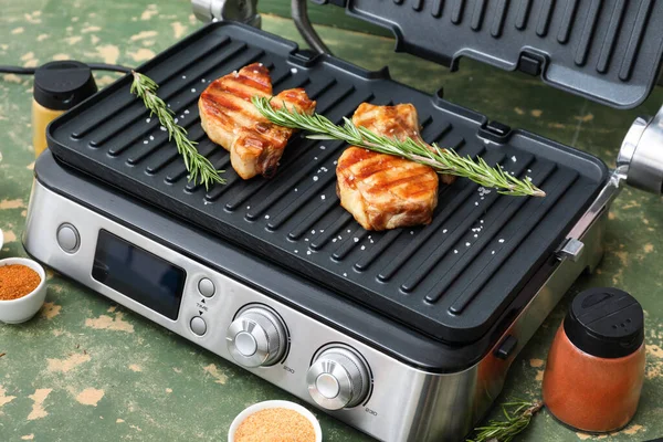 Modern Electric Grill Delicious Steaks Rosemary Spices Green Grunge Table — Stock Photo, Image