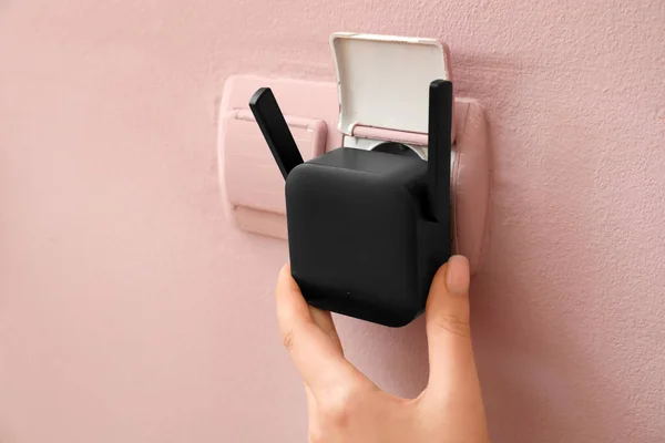 Mulher Plugando Repetidor Wifi Preto Tomada Elétrica Parede Rosa — Fotografia de Stock