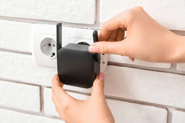 Woman Plugging Black Wifi Repeater Electric Socket White Brick Wall — Stock Photo, Image