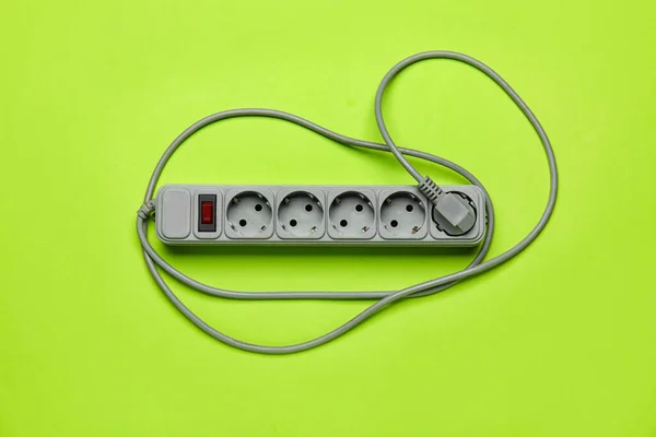 Electric extension cord on green background