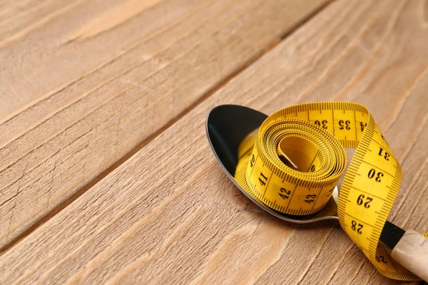 木制底座上的黄色测量带和勺子 — 图库照片