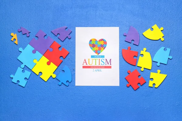 青い背景のパズルピースで世界自閉症啓発デーのためのカード — ストック写真