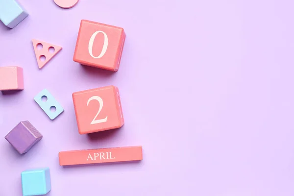 世界自闭症宣传日日期 背景为紫丁香的婴儿玩具 — 图库照片