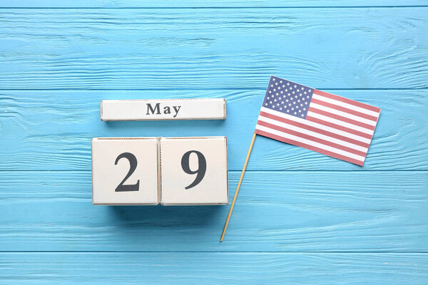 Date of Memorial Day with USA flag on blue wooden background