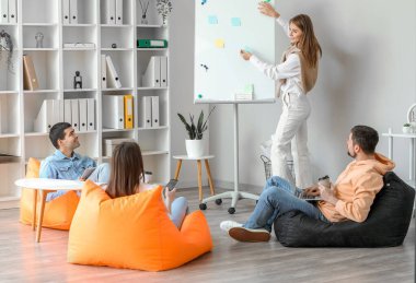 Ofiste iş planı üzerinde çalışan bir grup insan.