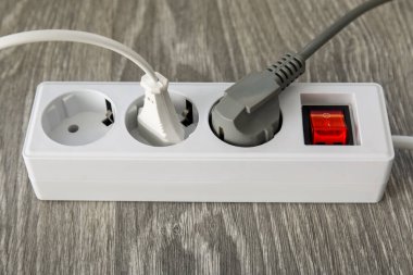 Tahta zemininde prizleri olan elektrik uzatma kablosu.